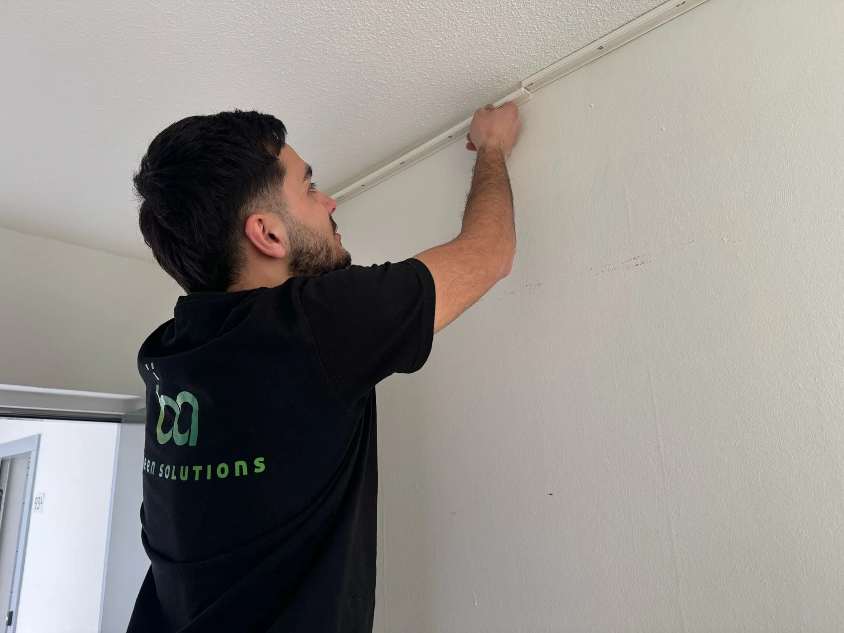 Monteur van B&A Green Solutions werkt aan kabelgoot bij plafond